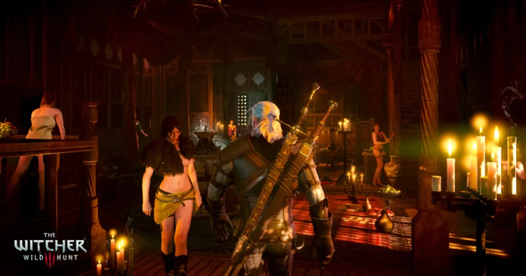 A video game screenshot of The Witcher 3: Wild Hunt. Geralt of Rivia, a white-haired witcher, is standing in a snowy forest. He is wearing a leather jacket and carrying two swords.